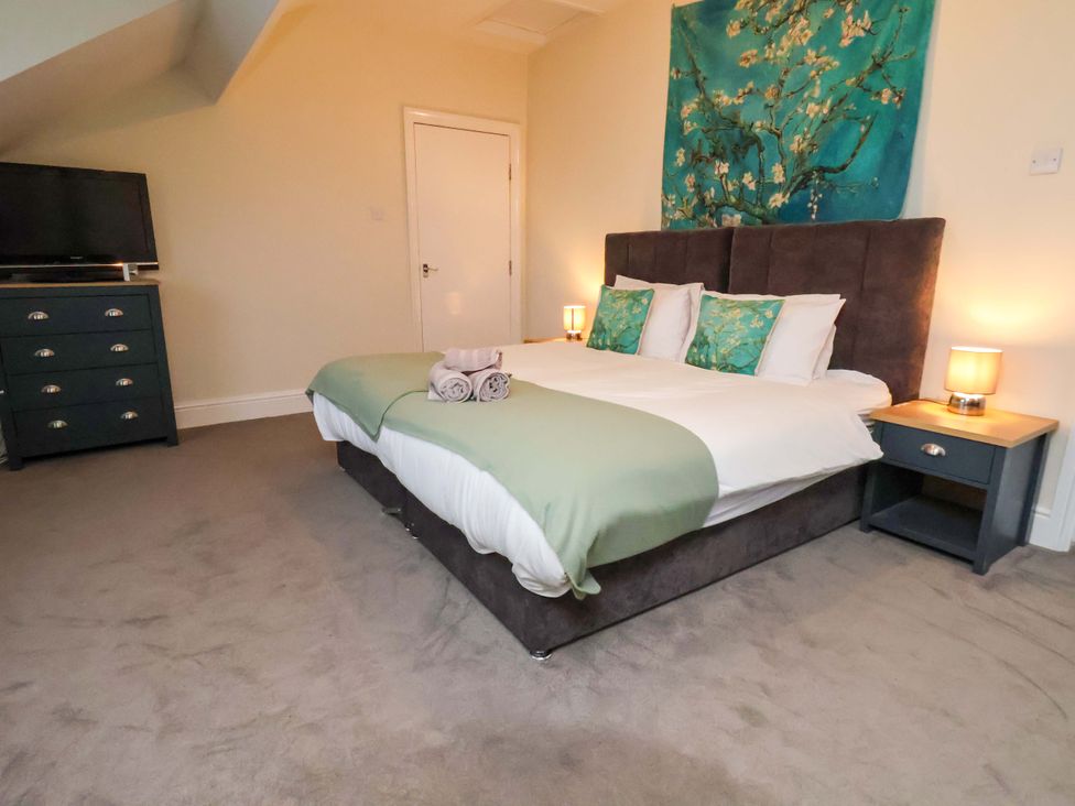 A bedroom with a bed and dresser at Wellington Lodge in Bridlington