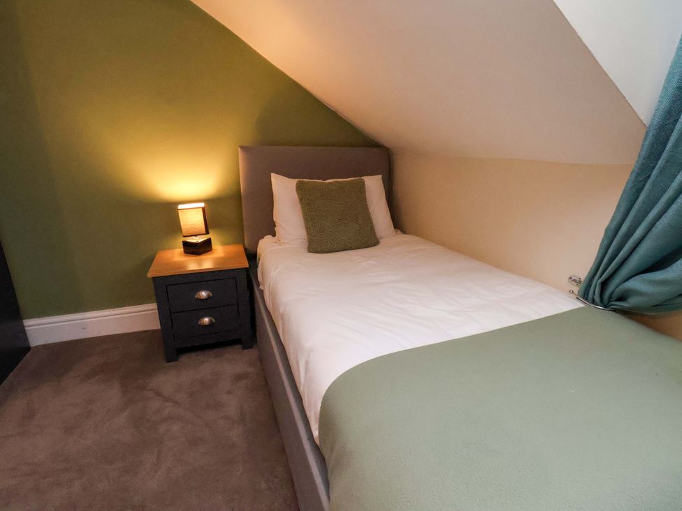 A bedroom with a single bed and bedside table at Wellington Lodge in Bridlington