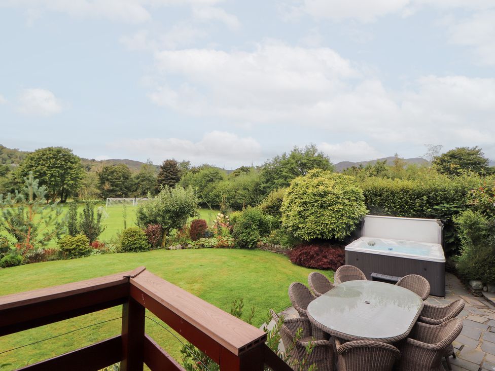 A garden with a hot tub and dining furniture at Bracken Howe in Ambleside