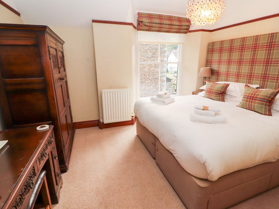 A bedroom with a bed and wardrobe at Bracken Howe in Ambleside