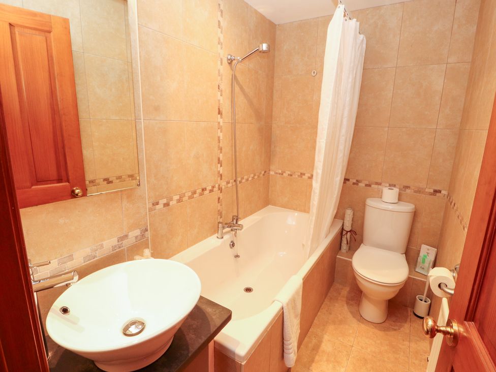 A bathroom with a bathtub and toilet at Bracken Howe Ambleside