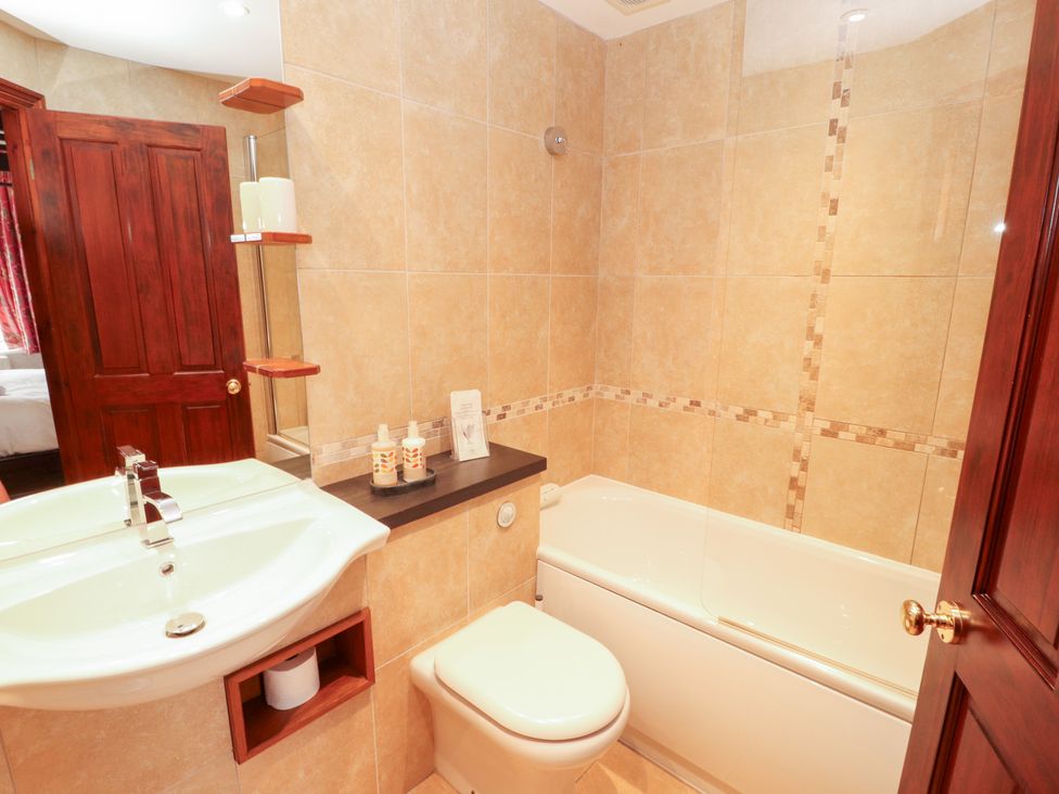 A bathroom with a sink, toilet, and bathtub at Bracken Howe in Ambleside