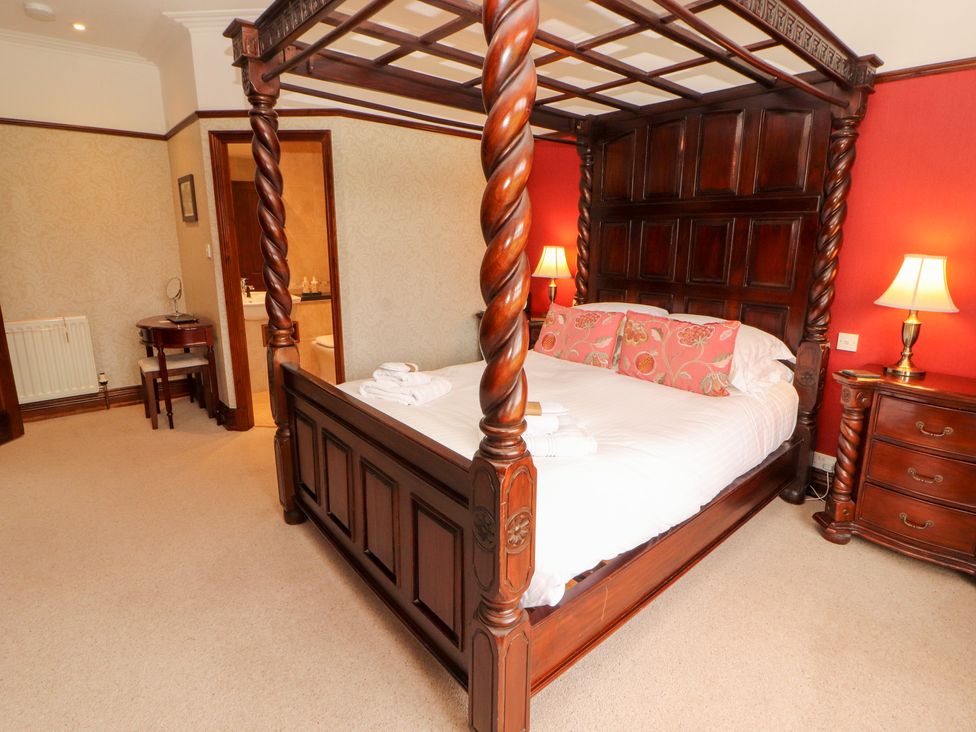 A bedroom with a four-poster bed and bedside lamps at Bracken Howe in Ambleside