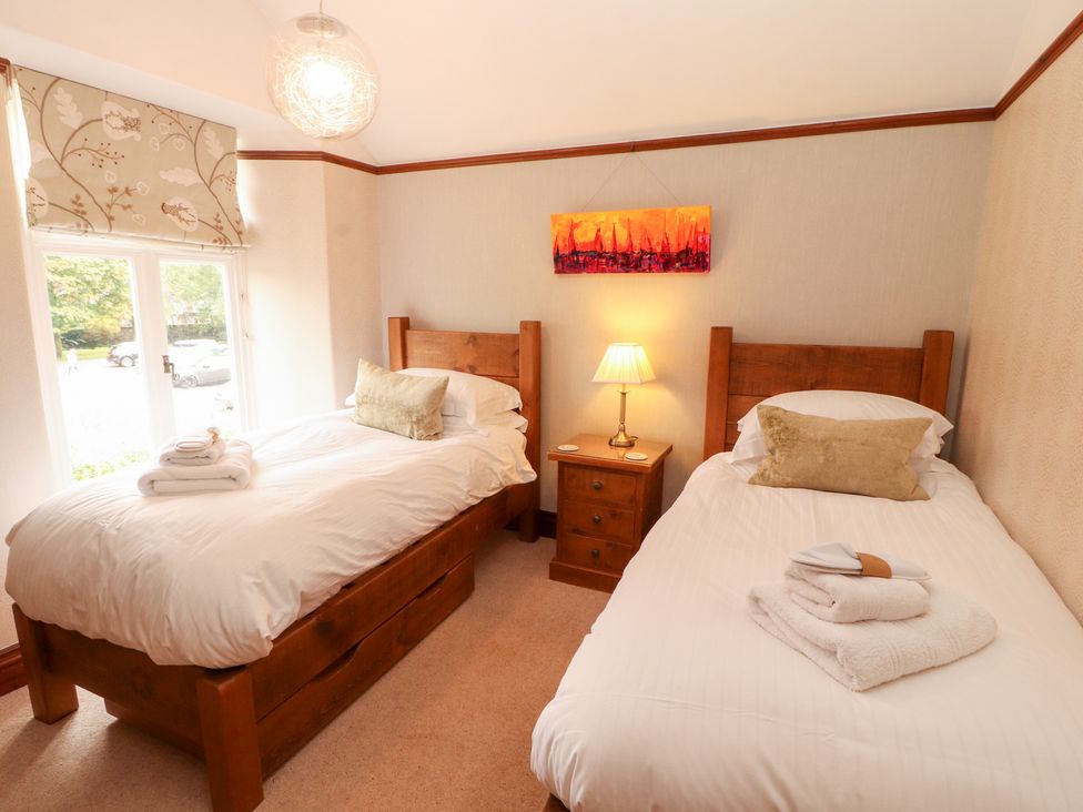 A bedroom with two beds and a nightstand at Bracken Howe in Ambleside