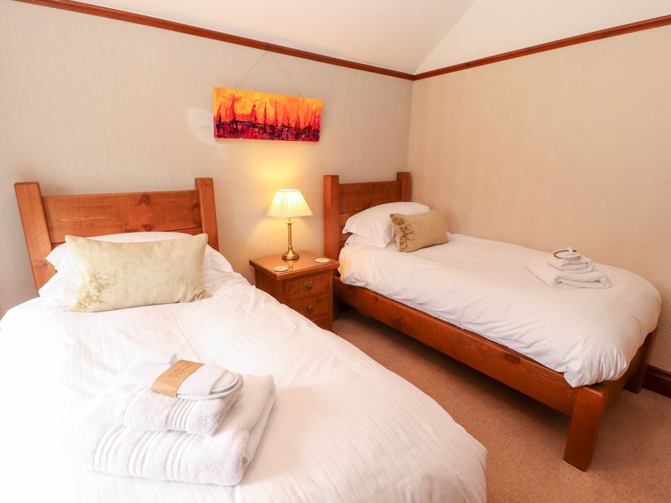 A bedroom with two single beds and a lamp at Bracken Howe in Ambleside