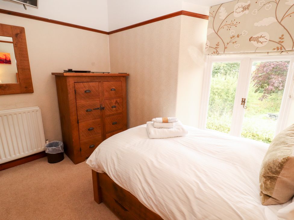 A bedroom with a bed and chest of drawers at Bracken Howe in Ambleside