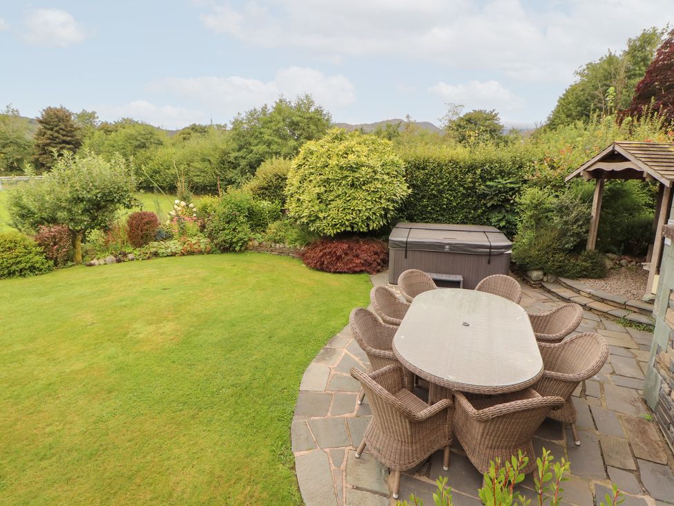 A garden with a dining table and chairs at Bracken Howe in Ambleside