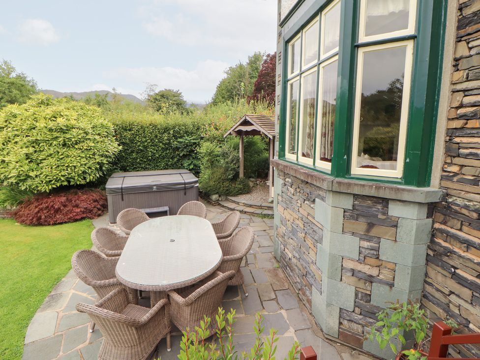 A garden with a table and chairs and a spa at Bracken Howe in Ambleside