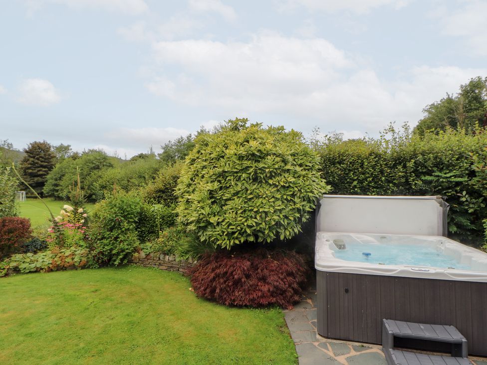 A garden with a hot tub and greenery at Bracken Howe in Ambleside