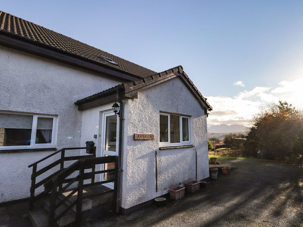 An exterior view of a house with steps and a sign at Arnaval in Carbost