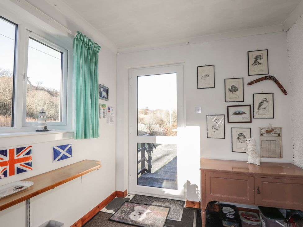 An entryway with a shelf and wall art at Arnaval in Carbost