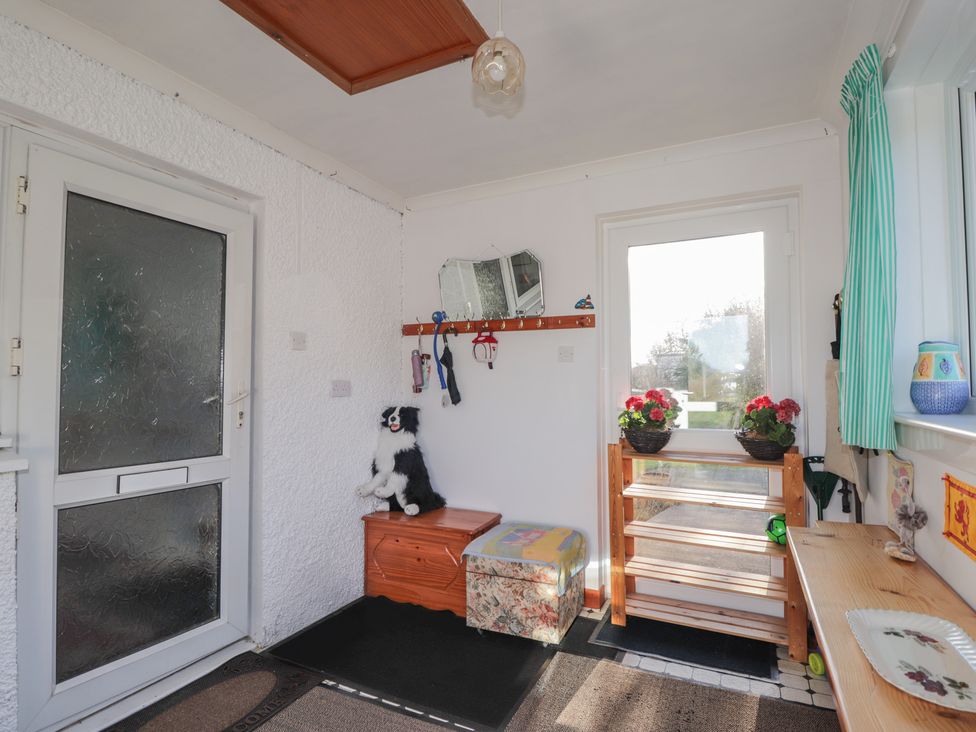 A hallway with a bench and dog figurine at Arnaval in Carbost