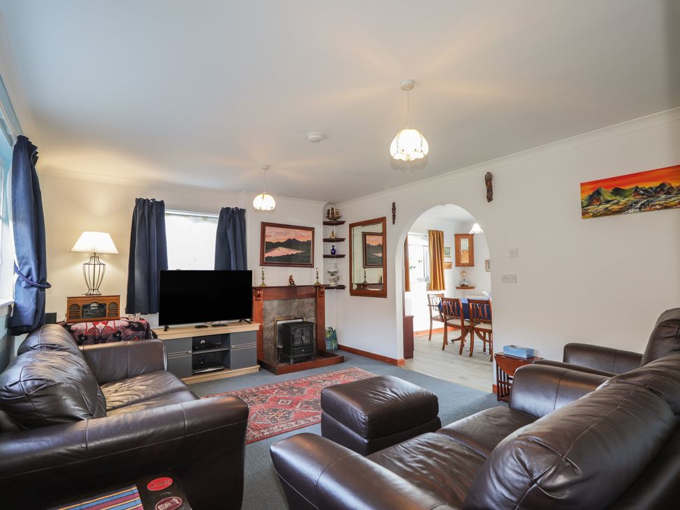 A living room with a television and fireplace at Arnaval in Carbost