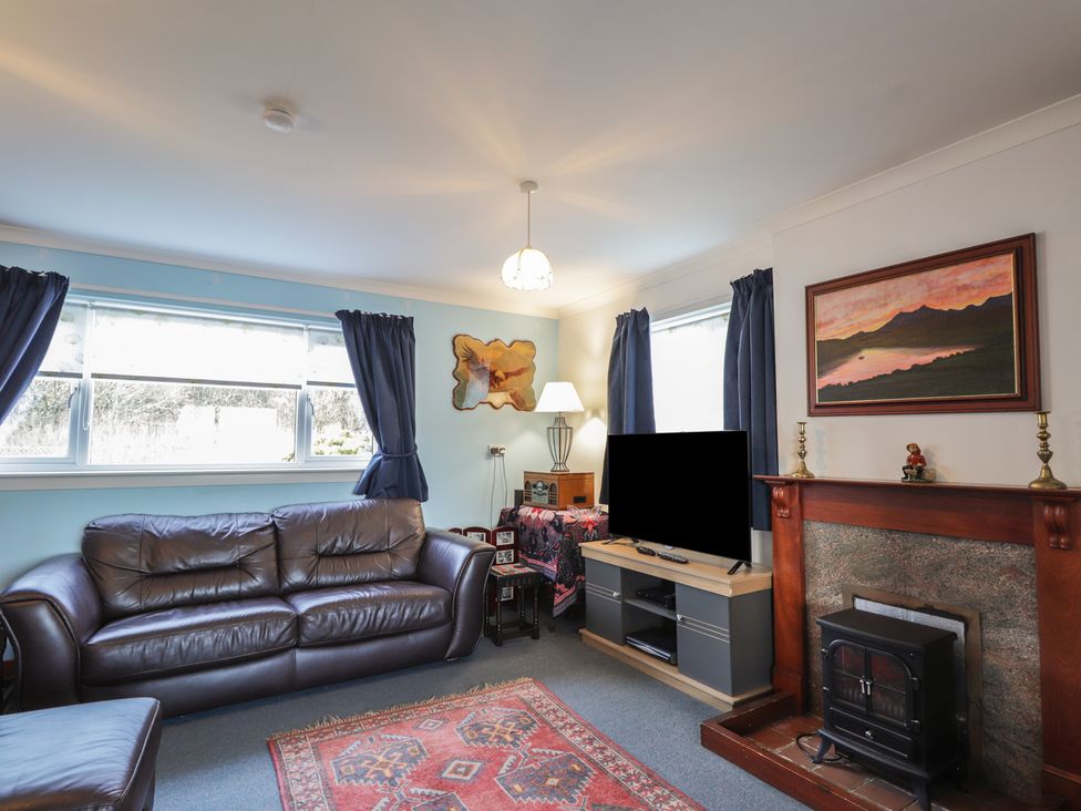 A living room with a sofa and television at Arnaval in Carbost