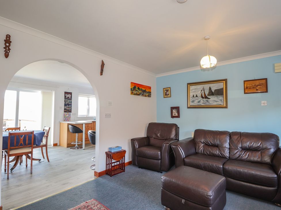 A living room with a sofa and armchair at Arnaval in Carbost
