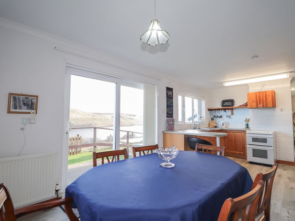 A kitchen with dining table and chairs at Arnaval in Carbost