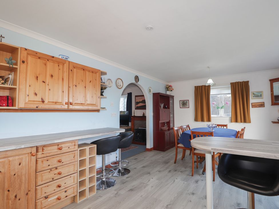 A kitchen with a dining area featuring a table and chairs at Arnaval in Carbost
