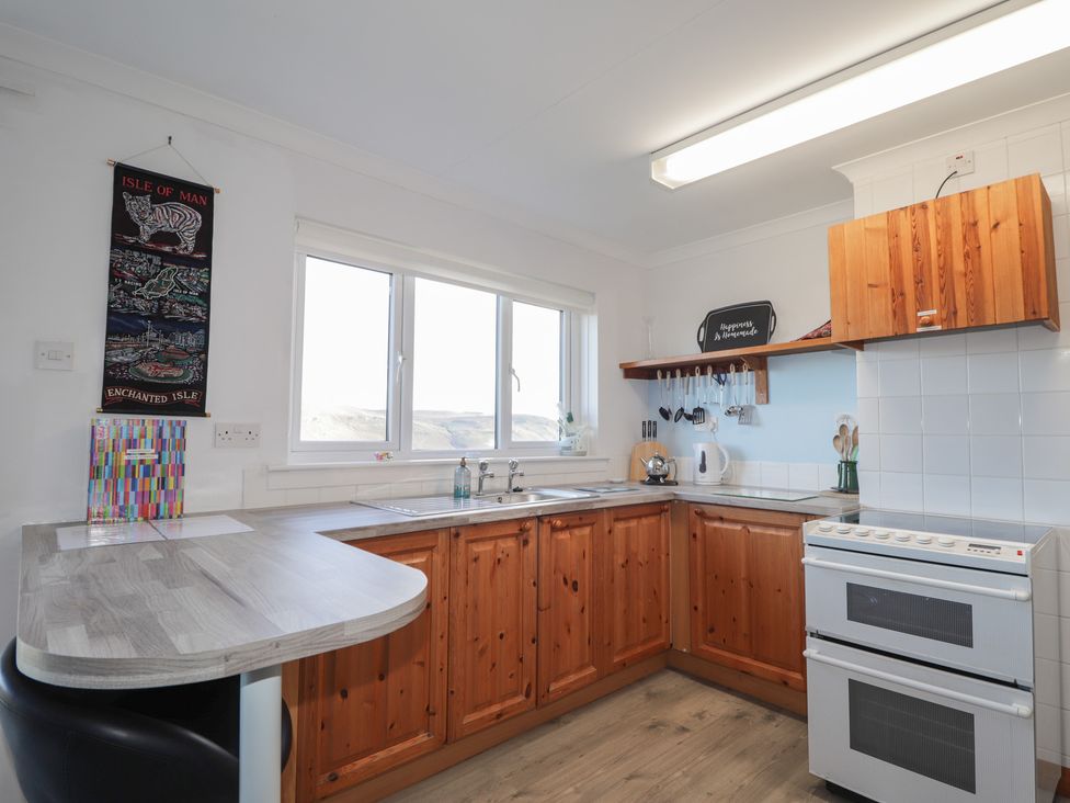 A kitchen with cabinets, sink, and stove at Arnaval in Carbost