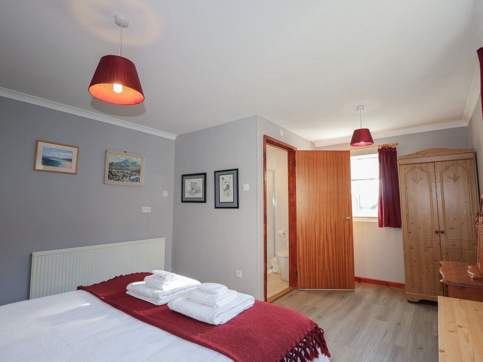 A bedroom with a double bed and a wardrobe at Arnaval in Carbost