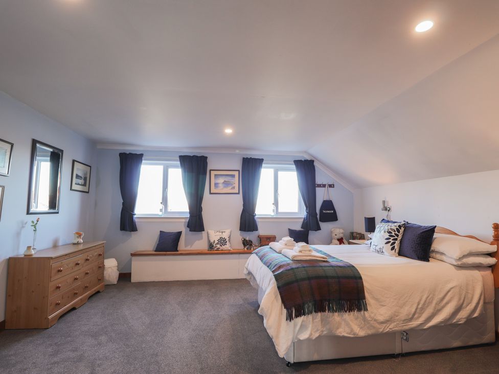 A bedroom with a bed and windows at Arnaval in Carbost