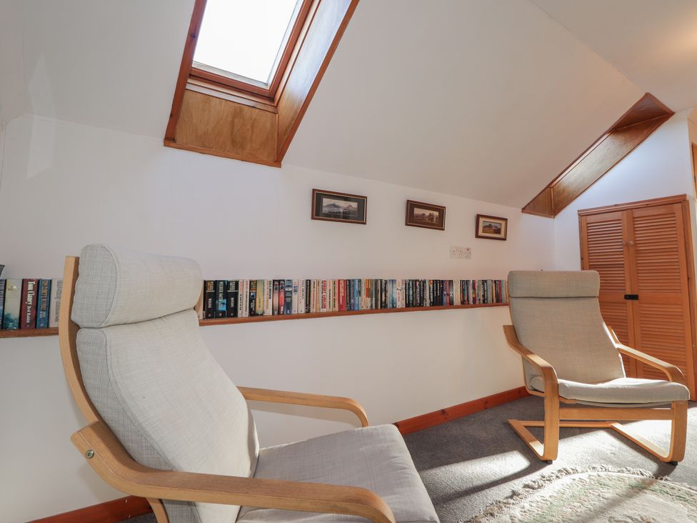 A snug with two rocking chairs and a bookshelf at Arnaval in Carbost