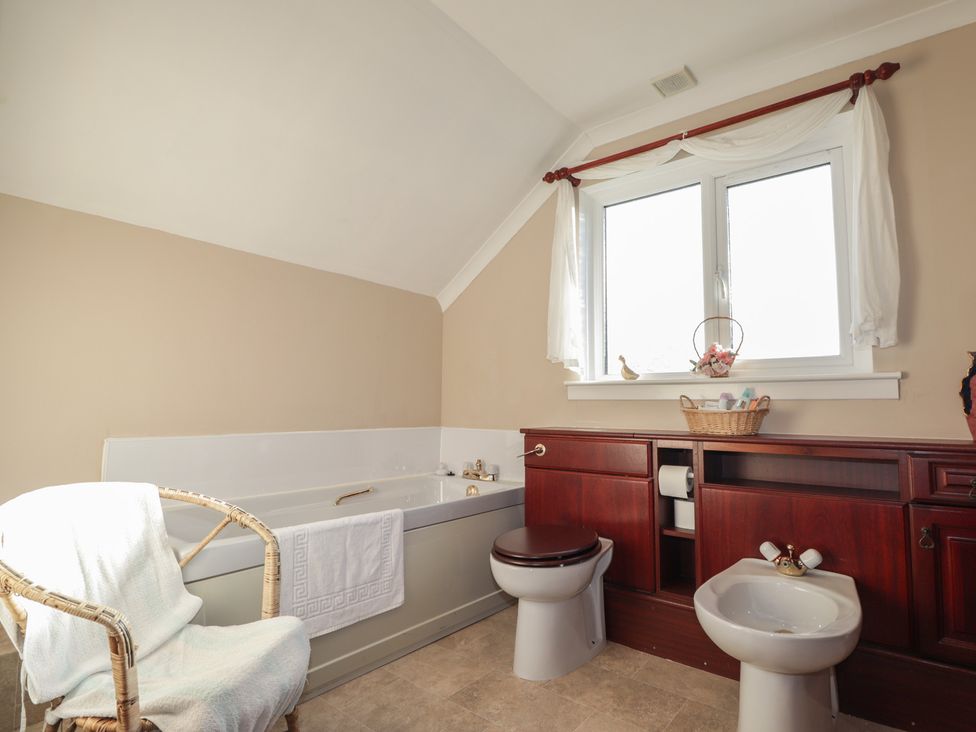 A bathroom with a bathtub, toilet, and sink at Arnaval in Carbost