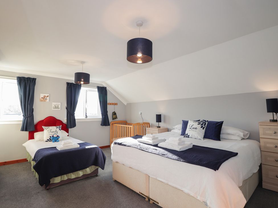 A bedroom with two beds and a crib at Arnaval in Carbost