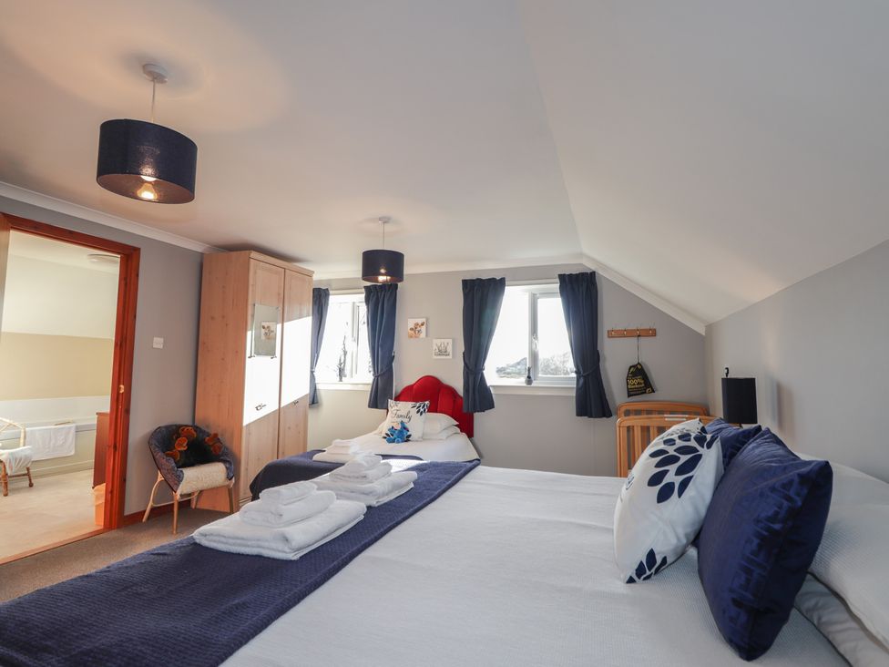 A bedroom with two beds and a wardrobe at Arnaval in Carbost