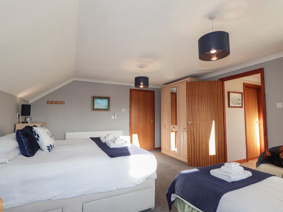 A bedroom with beds and wardrobe at Arnaval in Carbost