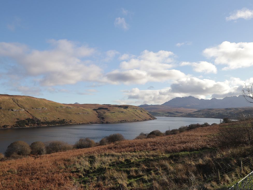 A view of a lake surrounded by hills and mountains at Arnaval in Carbost