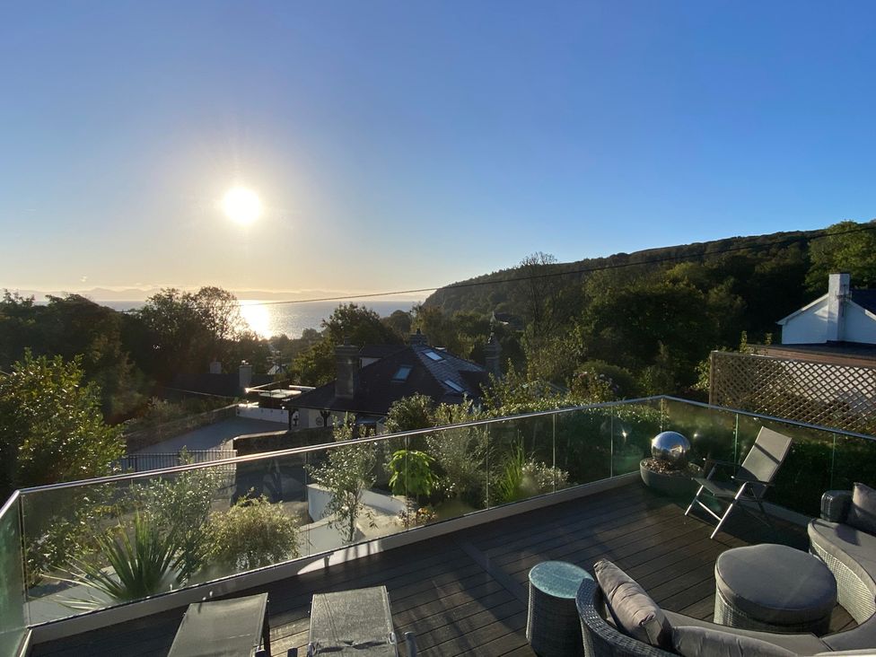Outdoor area with seating and ocean view at Woodcroft in Pwllheli