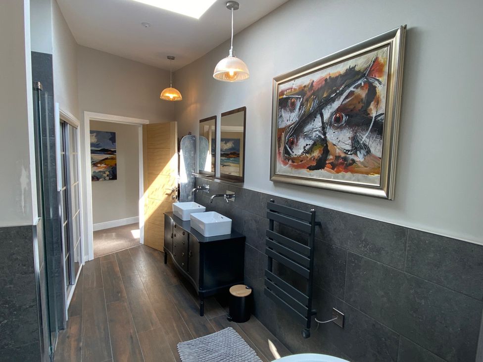 A bathroom with sinks and mirrors at Woodcroft in Pwllheli