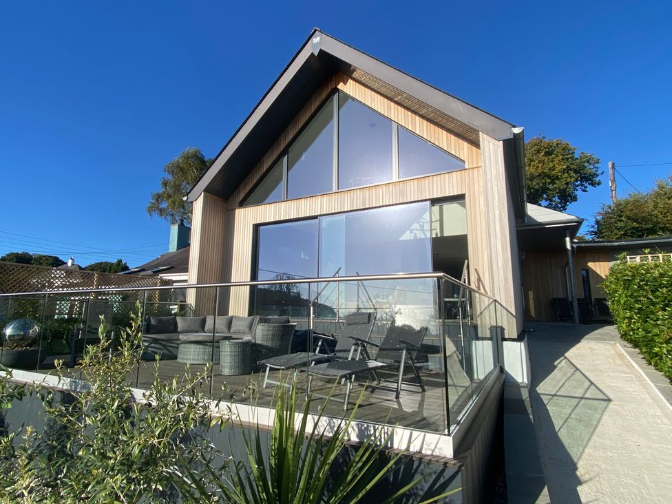 A house with a patio and seating area at Woodcroft in Pwllheli