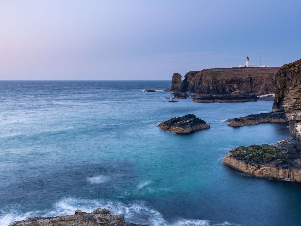 A coastal view featuring a lighthouse on a cliff at The Lighthouse Keepers Cabin, Noss Head near Wick, Caithness