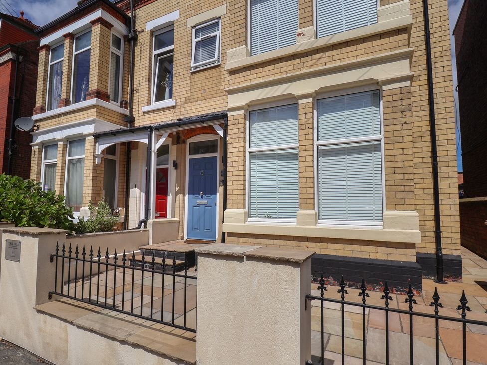 A front view of a house with a blue door at Coral Villa in Bridlington