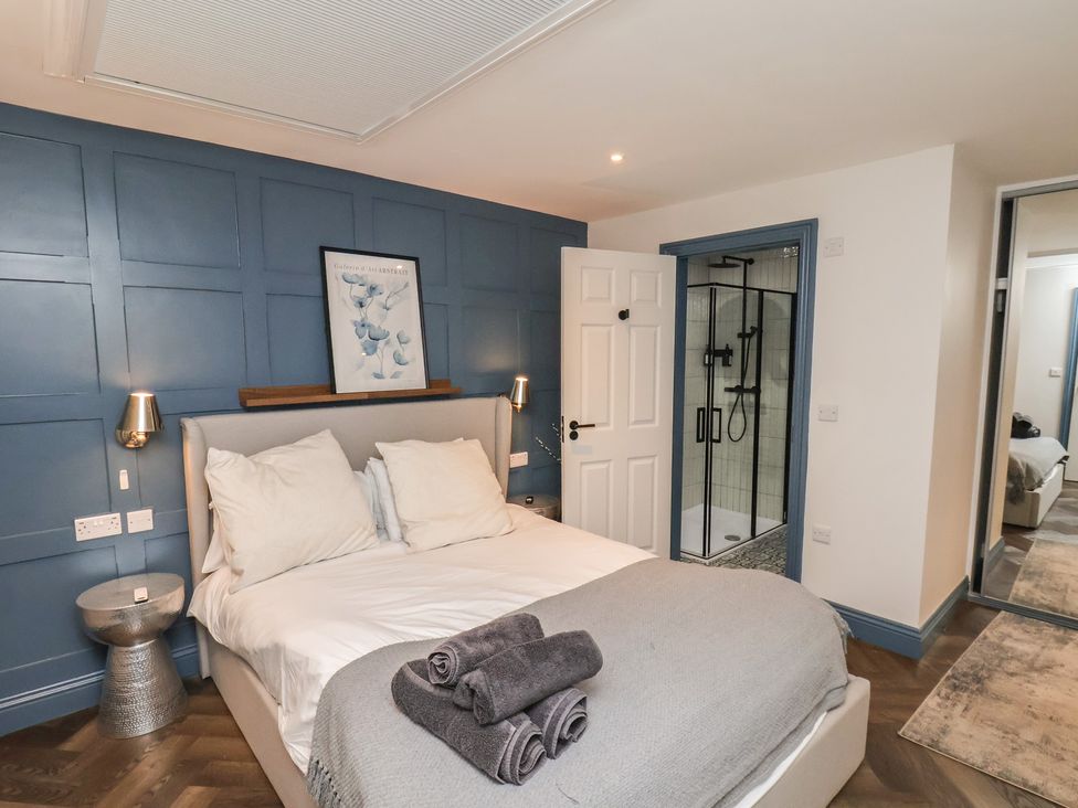 A bedroom with a bed and a shower at Coral Villa in Bridlington