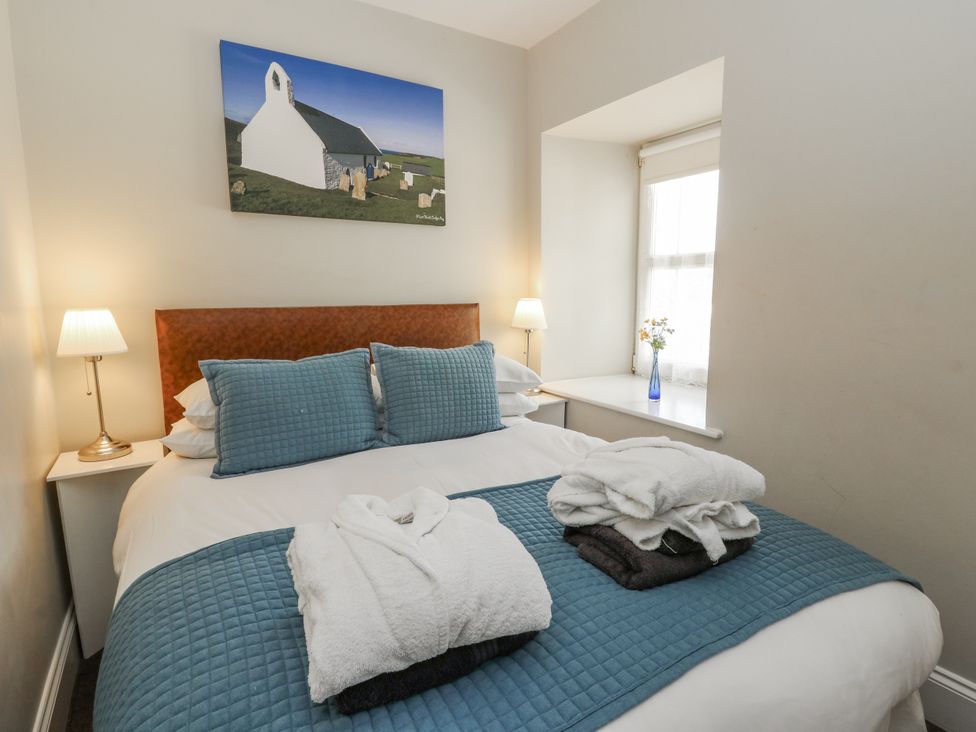 A bedroom with a bed and lamps at Station Hall in Cilgerran