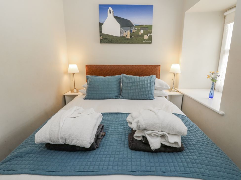 A bedroom with a bed and lamp at Station Hall in Cilgerran