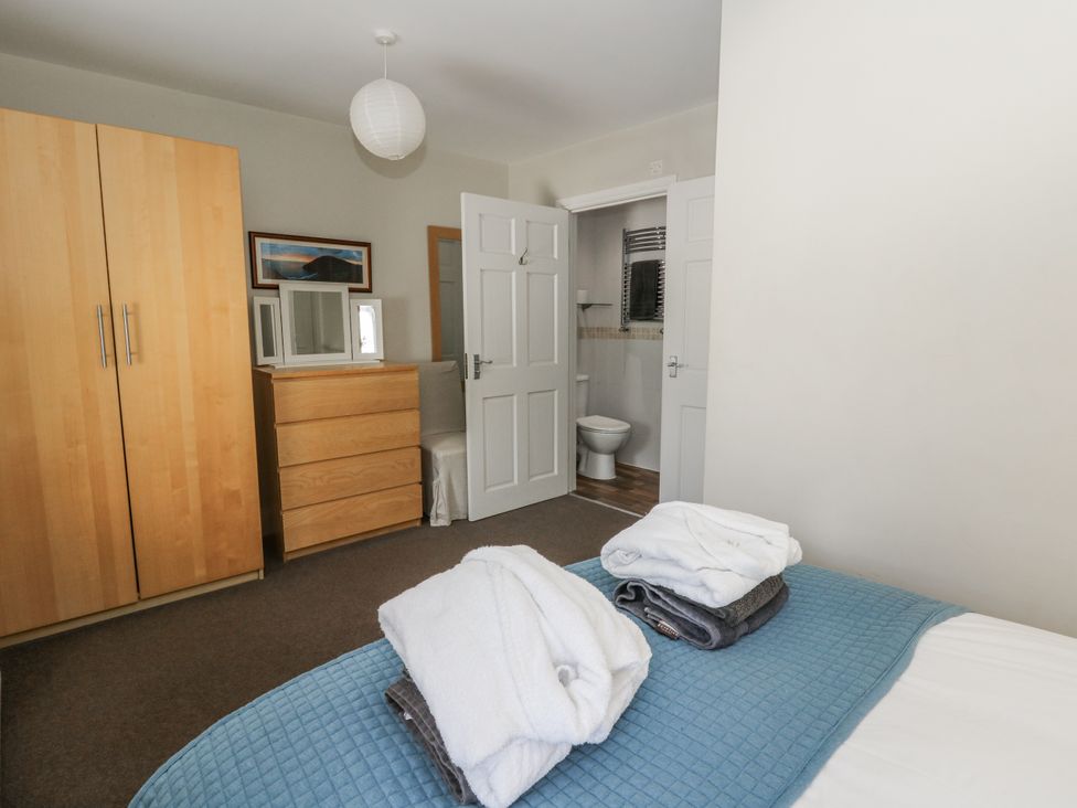 A bedroom with a wardrobe and chest of drawers at Station Hall in Cilgerran
