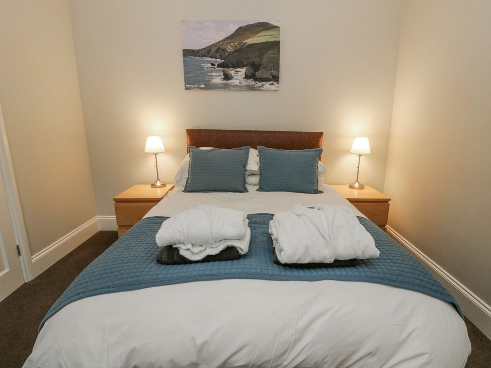 A bedroom with a bed and bedside lamps at Station Hall in Cilgerran