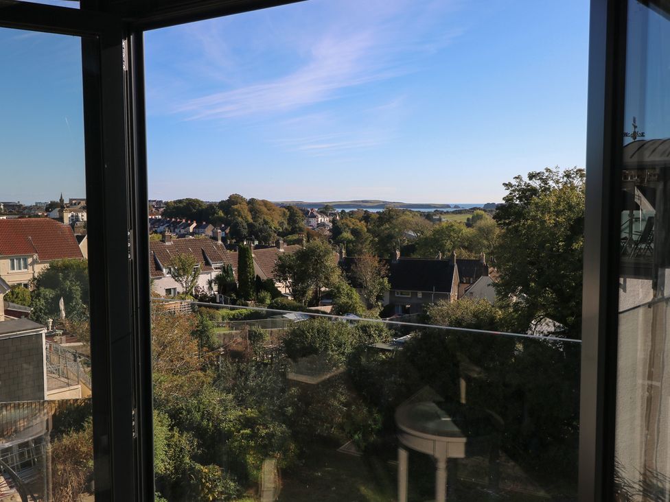 A view from a window showing houses and trees at 9 Brython Place Tenby