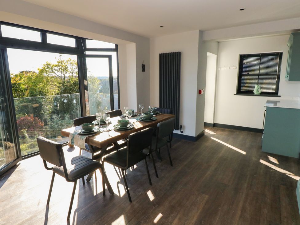 A dining room with a table set for meals at 9 Brython Place Tenby