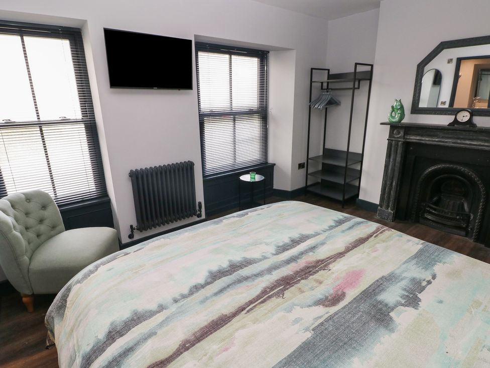 A bedroom with a bed and a sofa at 9 Brython Place Tenby