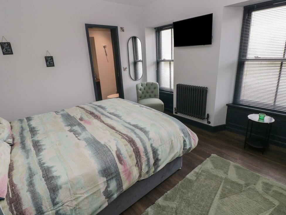 A bedroom with a bed and television at 9 Brython Place in Tenby