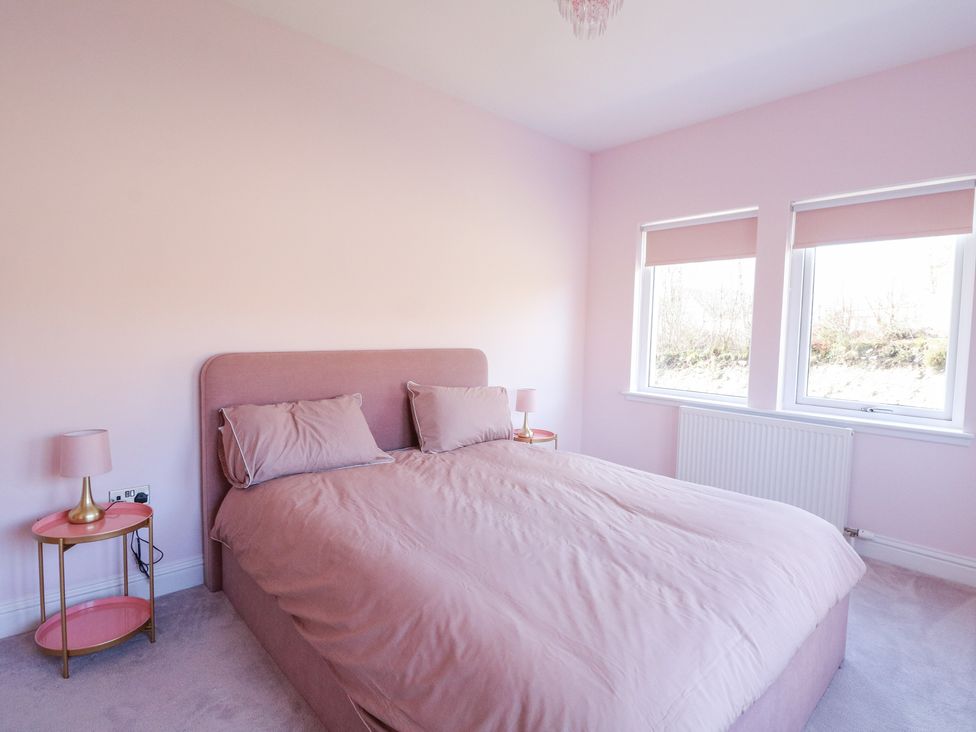 A bedroom with a double bed and two matching bedside tables with lamps at Macgregor Ranch in Achnabobane near Spean Bridge