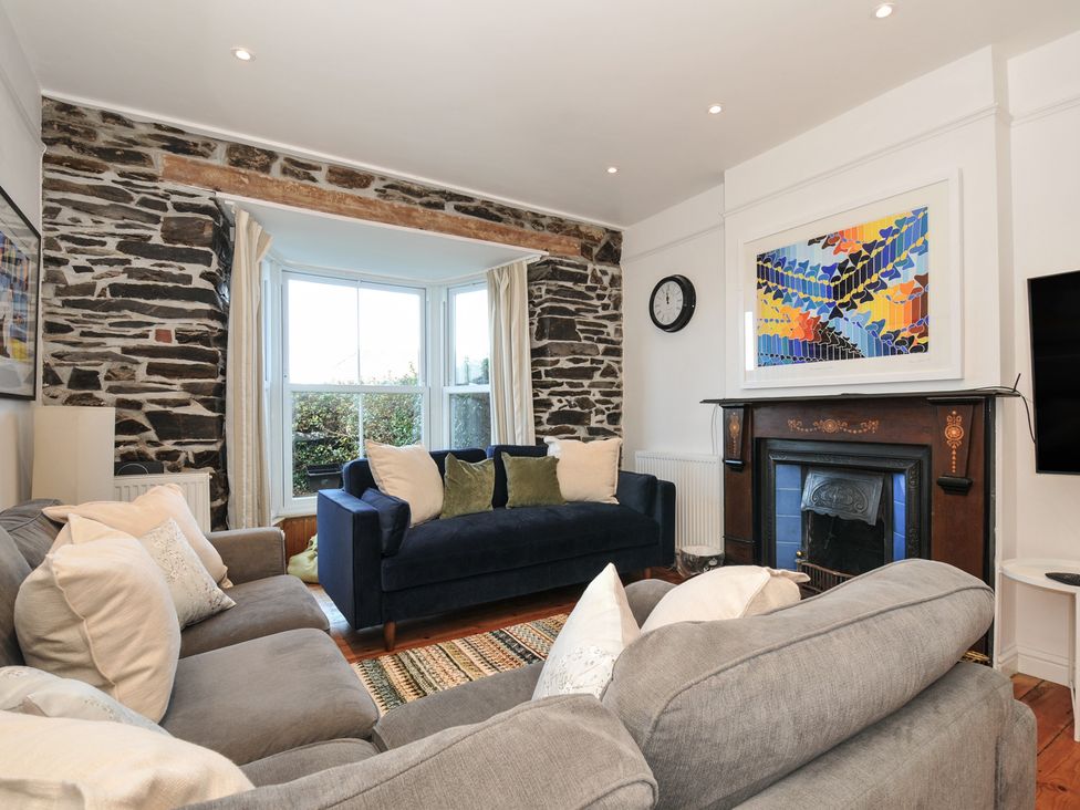 A living room with a blue sofa and armchair at 2 Glyddins 1910 Rock