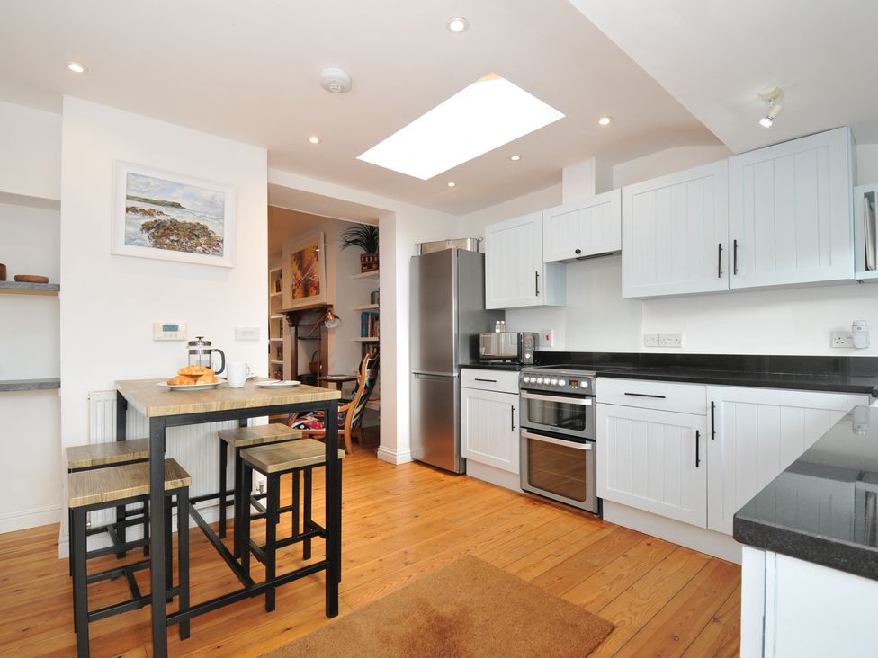 A kitchen with a table and stools at 2 Glyddins 1910 in Rock
