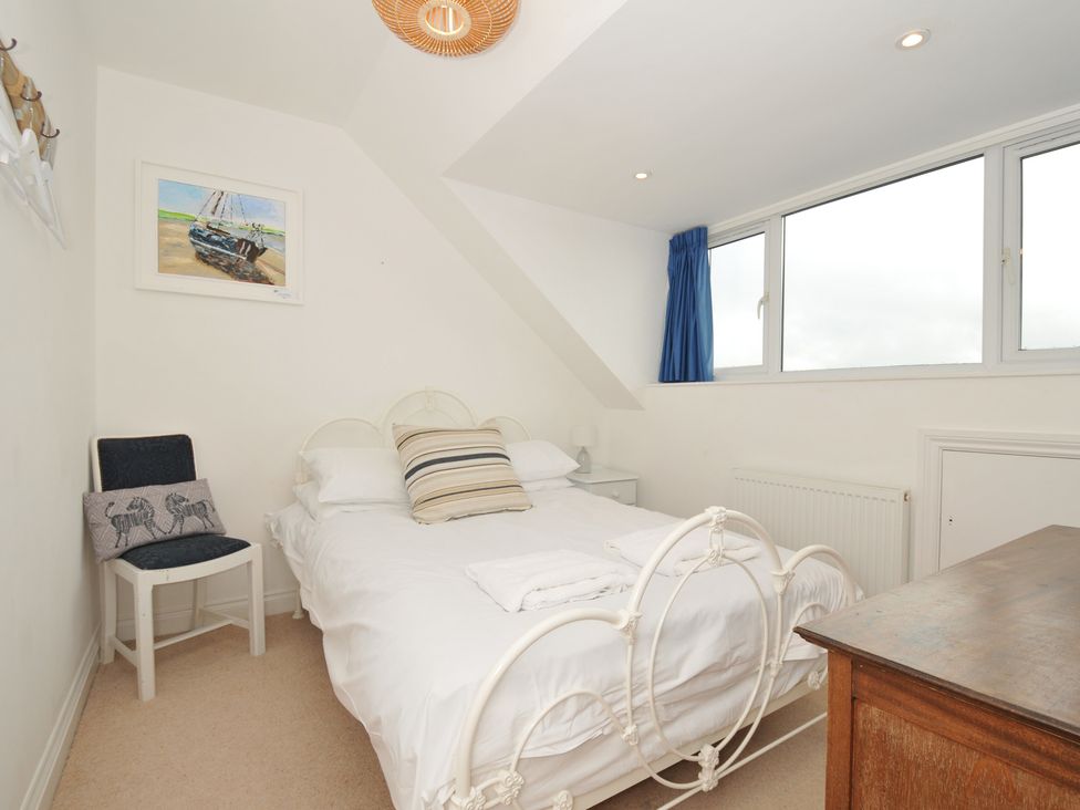 A bedroom with a bed, chair, and painting at 2 Glyddins 1910 in Rock