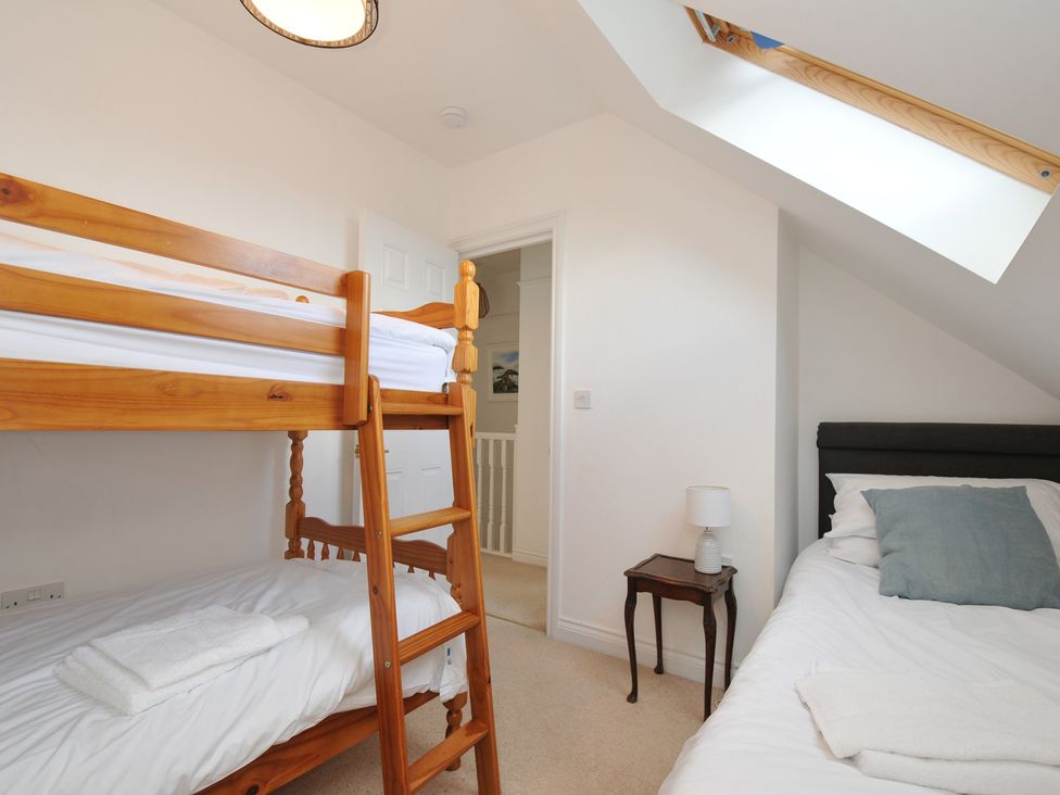 A bedroom with a bunk bed and a single bed at 2 Glyddins 1910 Rock