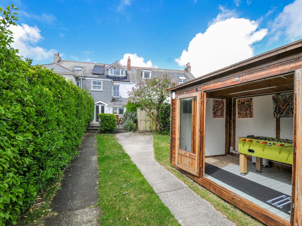 A garden with a pathway and a shed containing a foosball table at 2 Glyddins 1910 Rock